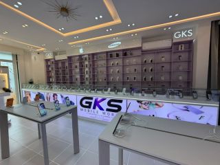 L'intérieur de la boutique : rayonnages lavande garnis de téléphones, comptoir vitré et tables d'essai